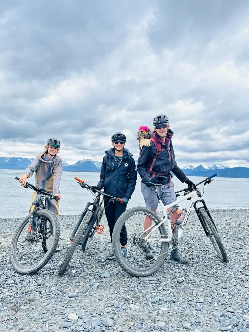 The O'Neal family, Tyler, Melissa, and Kypton on mountain bikes with Luna the bernedoodle wearing her signature goggles